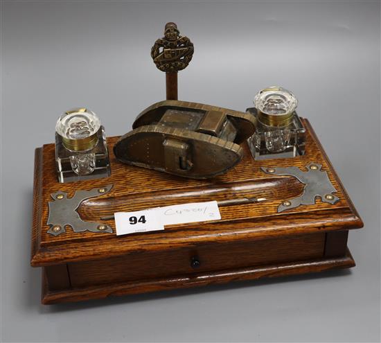 A late Victorian oak inkstand, with later brass trench art tank surmount width 28cm